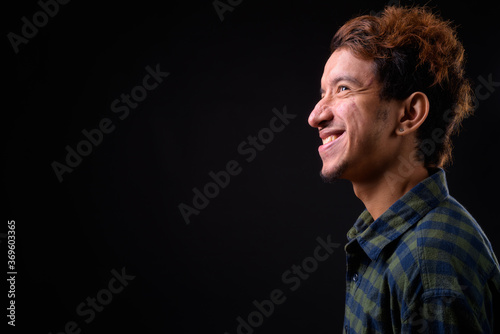 Portrait of happy young Asian hipster man with curly hair