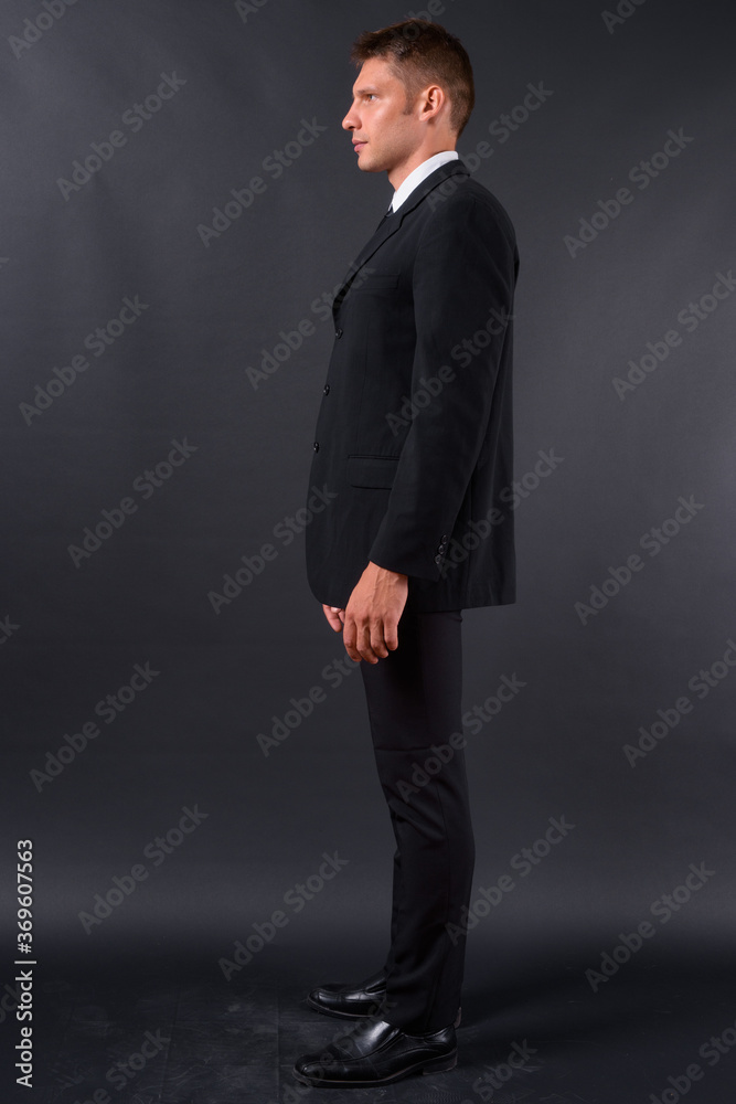 Portrait of businessman in suit against black background Portrait of businessman in suit against black background