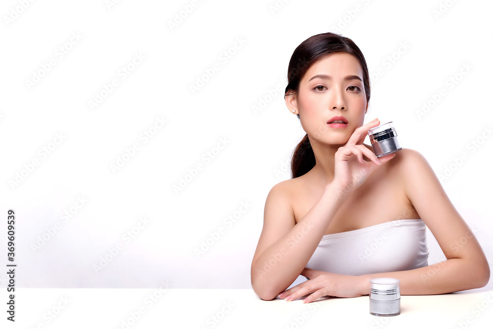 Portrait of beautiful charming young Asian woman posing facial with cosmetic and sitting with white table, beauty of female face with skincare on white background, healthcare and skin care concept. Portrait of beautiful charming young Asian woman posing facial with cosmetic and sitting with white table, beauty of female face with skincare on white background, healthcare and skin care concept.