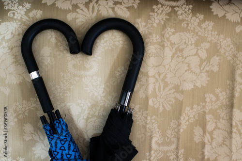 Obraz na plátne Top view closeup of two umbrella handles forming a heart shape