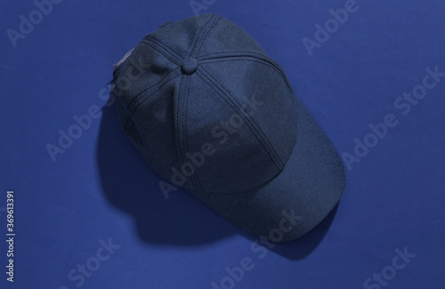 Jeans blue Cap on classic blue bright background with deep shadow. Top view