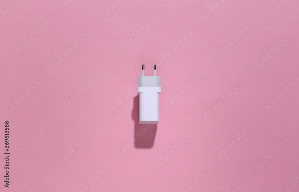 Charger adapter on pink bright background with deep shadow. Top view. Flat lay. Minimalism Charger adapter on pink bright background with deep shadow. Top view. Flat lay. Minimalism