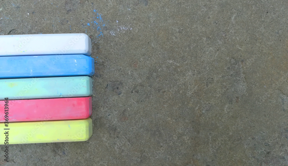multi-colored crayons lie on the asphalt. fun summer game. children drawing, creativity, banner, place for text, copy space