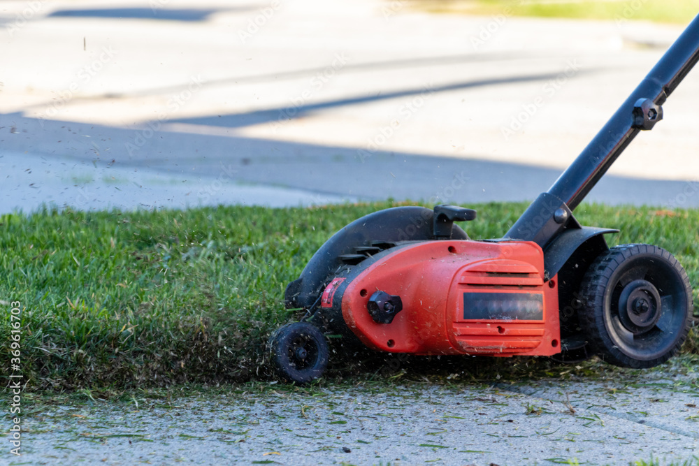 Grass flying in the air after being cut by an edger on a sunny winter afternoon. Grass flying in the air after being cut by an edger on a sunny winter afternoon.