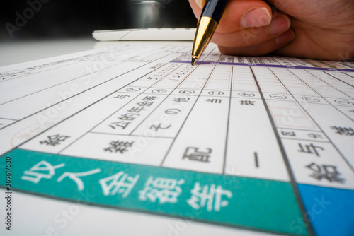Close-up view of completing Japanese tax form photo