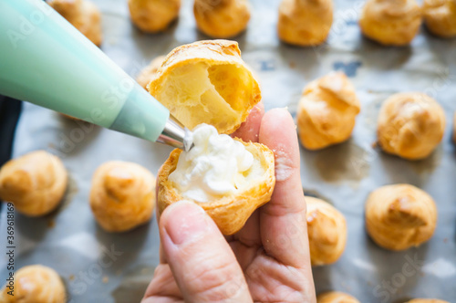 squeeze whipping cream into cream puffs