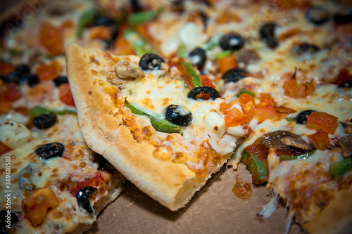 a slice of pizza with olives lies in a box