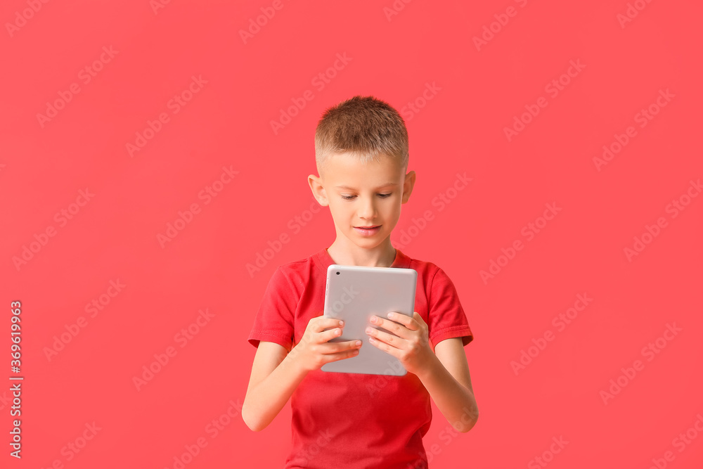 Cute little boy with tablet computer on color background Cute little boy with tablet computer on color background