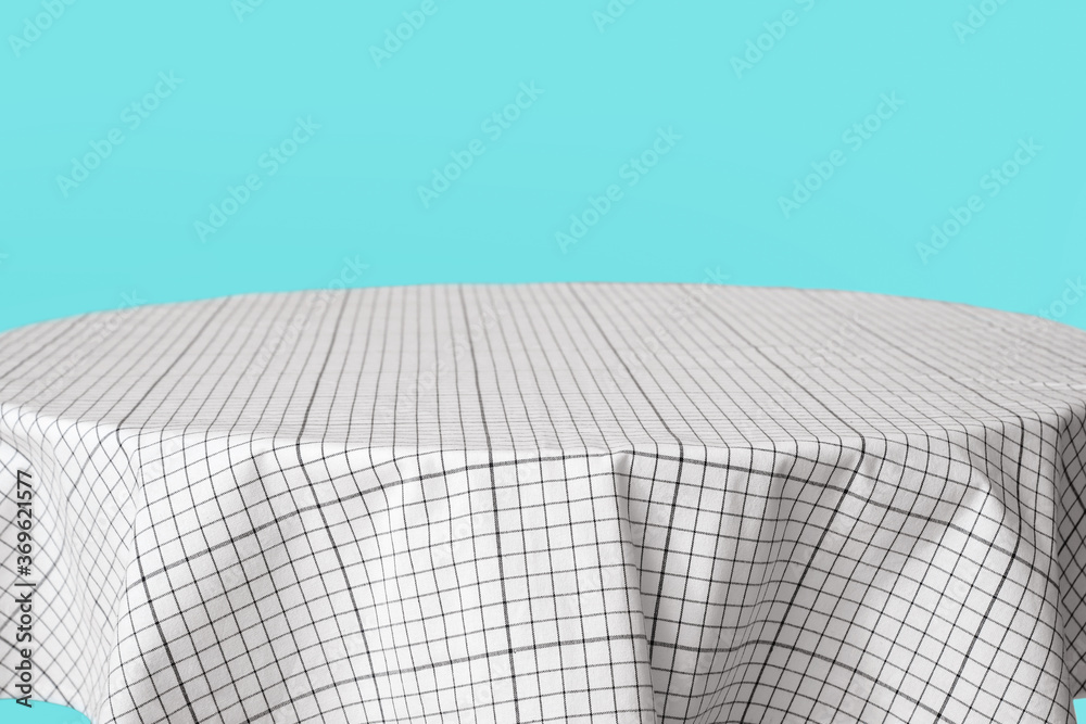 Obraz premium Dining table with tablecloth on color background