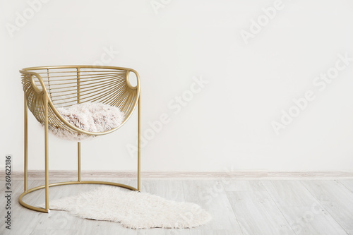 Stylish armchair near light wall