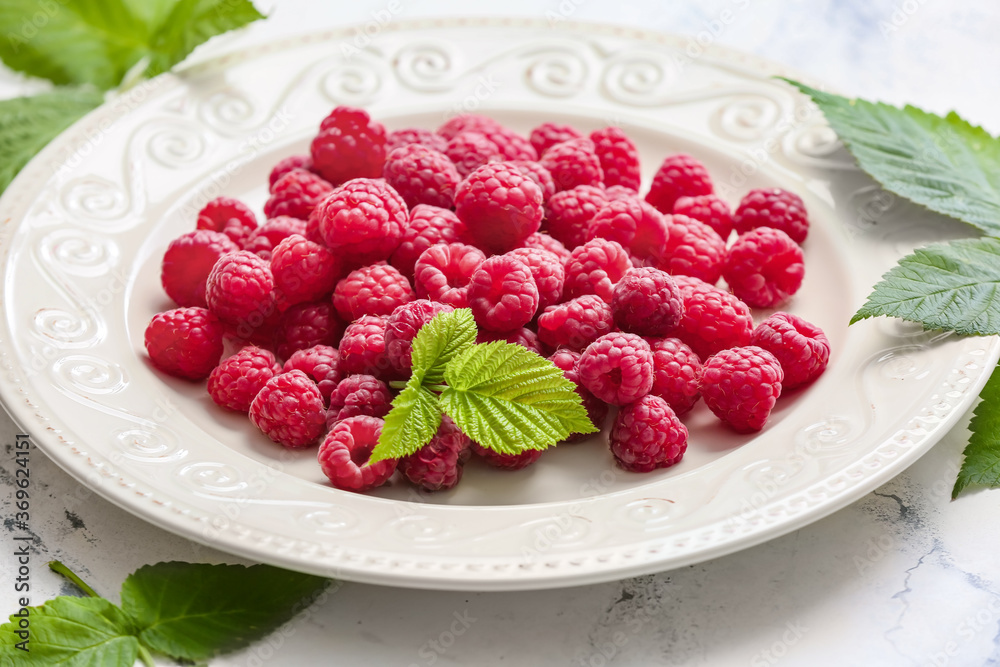 Plate with ripe raspberries on table, closeup - obrazy, fototapety, plakaty 