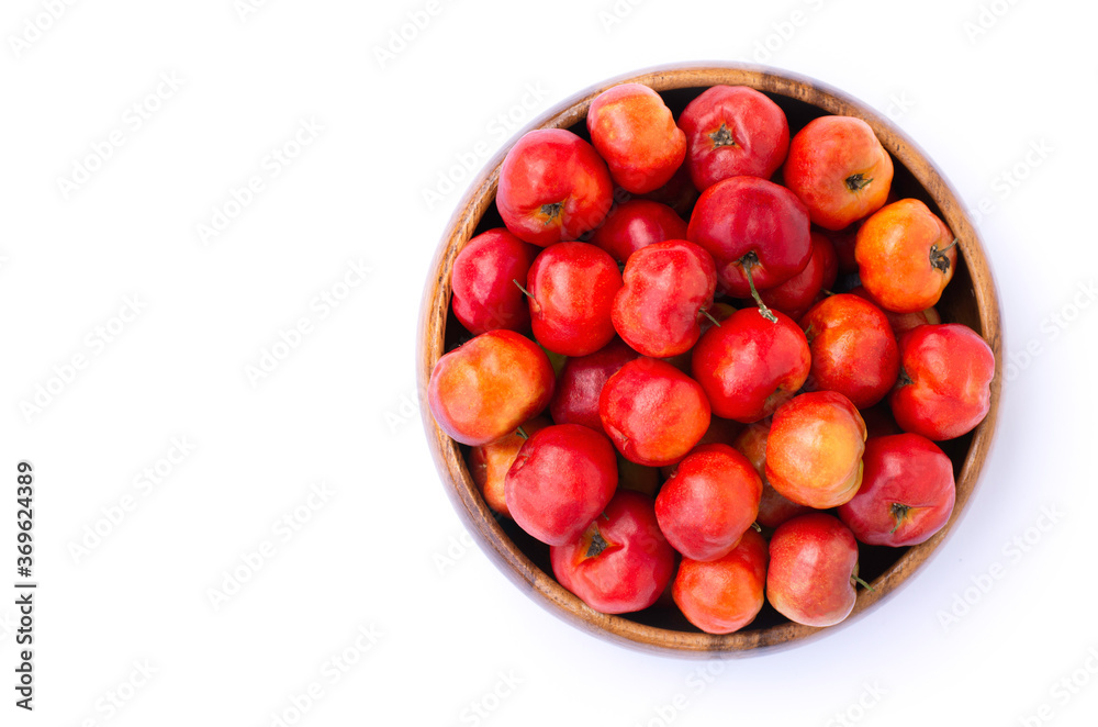 red acerola cherry fruit in wooden bowl isolated on white background. Top view. red acerola cherry fruit in wooden bowl isolated on white background. Top view.