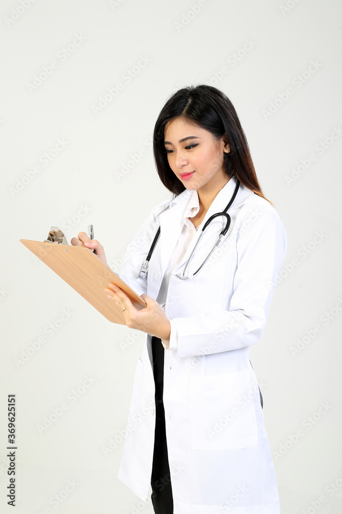 Young Asian female doctor wearing apron stethoscope holding writing on a clipboard Young Asian female doctor wearing apron stethoscope holding writing on a clipboard