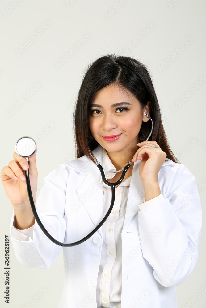 Young Asian female doctor wearing apron holding stethoscope Young Asian female doctor wearing apron holding stethoscope