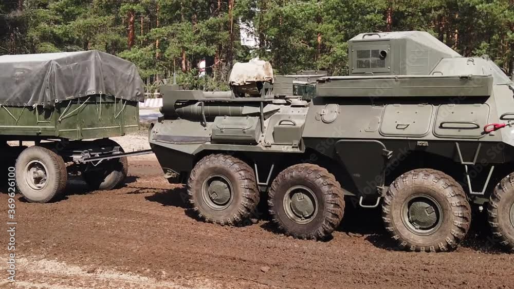APCS of personnel with a cargo trailer are going to dust on the ground for military exercises. Travels at great speed through the forest. Slow motion APCS of personnel with a cargo trailer are going to dust on the ground for military exercises. Travels at great speed through the forest. Slow motion