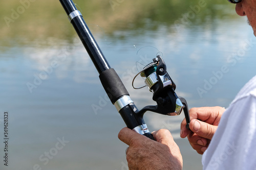 Fishing in river.A fisherman with a fishing rod on the river bank. Man fisherman catches a fish.Fishing, spinning reel, fish, Breg rivers. The concept of a rural getaway. Article about fishing