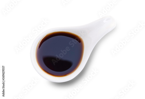 soy sauce in small bowl and chopsticks isolated on white background.