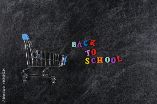 Preschool shopping. Supermarket trolley on chalk board with text Back to School.