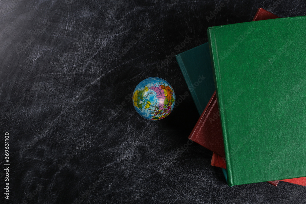 Geography lesson. A stack of books and a globe on a chalk board. Top ...