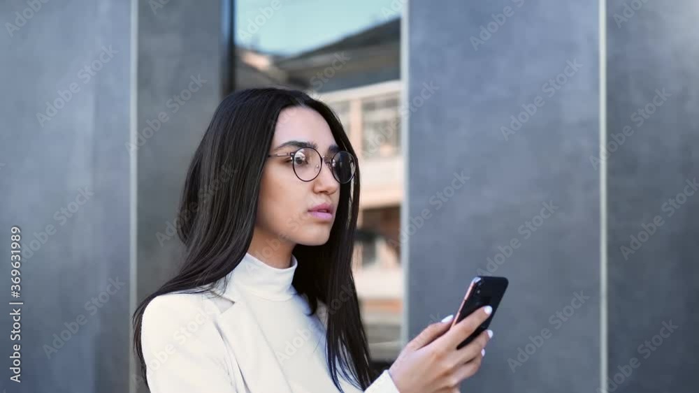 Confident business woman walking outdoor chatting use smartphone. Close up shot on 4k RED camera