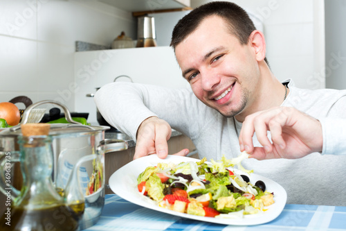 Portrait of smiling male with vegetables dish at kitchen