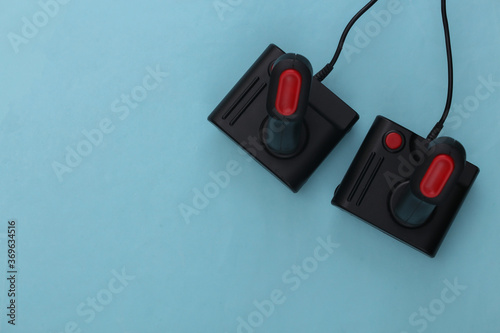 Two retro joysticks on blue background. Gaming, video game competition. Top view, minimalism