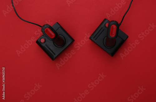 Retro joysticks on red background. Gaming, video game competition. Top view