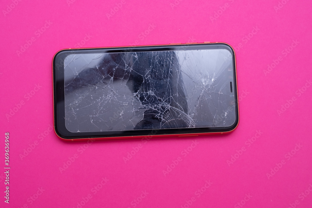 Broken glass mobile phone screen on a pink background. Broken glass mobile phone screen on a pink background.