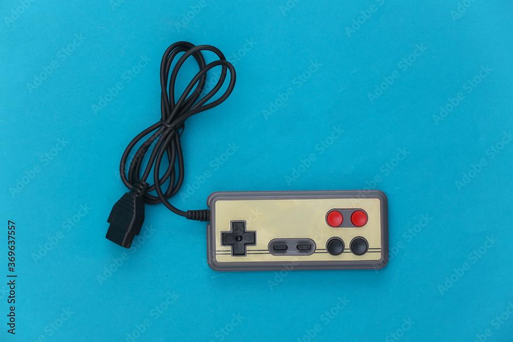 Wired retro gamepad (joystick) on a blue background. Top view Wired retro gamepad (joystick) on a blue background. Top view