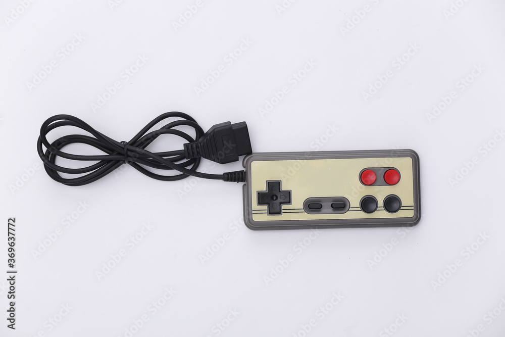 Wired retro gamepad (joystick) with wound cable on white background. Video game, gaming. Top view Wired retro gamepad (joystick) with wound cable on white background. Video game, gaming. Top view