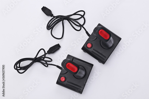 Two wired retro joysticks with wound cable on white background. Video game, gaming. Top view