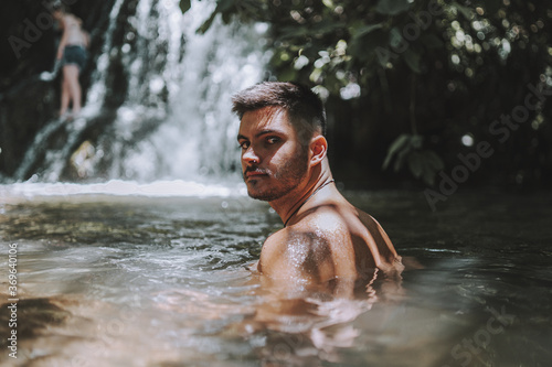 Young male relaxing near the Hueznar waterfall in the Sierra Norte natural park in Spain photo