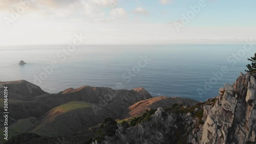 Sensational exhilarating scenic landscape flyover above Juliana peak towards beautiful vast blue ocean sea water on sunny sky day, Porto Santo Island, Portugal, overhead aerial approach photo