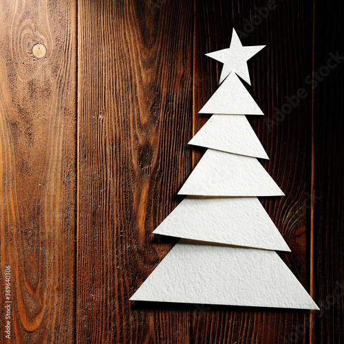 Christmas tree cut out from paper on a wooden background