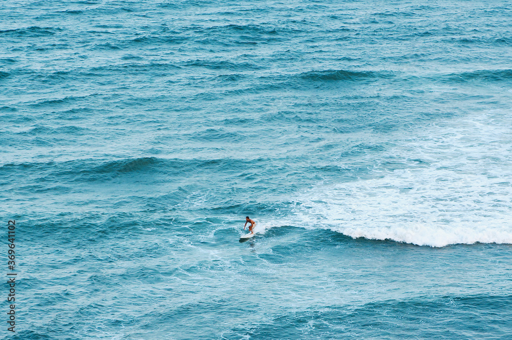 ハワイ・ホノルルでサーフィンをする男性