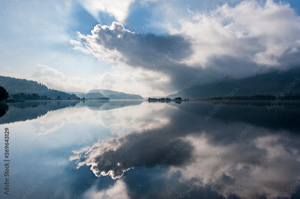 flat mirror like lake and dramatic clouds in the mountains flat mirror like lake and dramatic clouds in the mountains