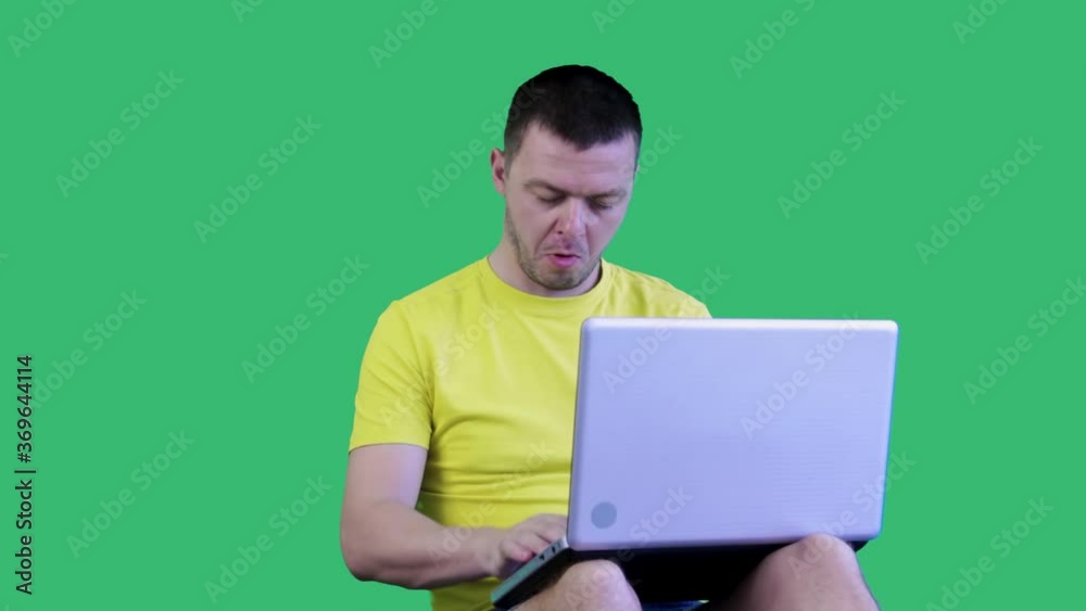 Man with a laptop on a green background.Chromakey