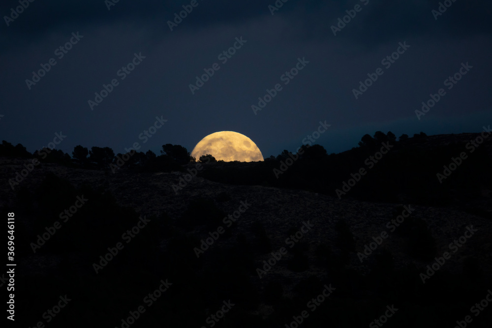 full moon rising on a mountain