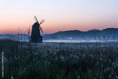 The beautiful foggy landscape of windmill town and patk in the early morning at dawn. photo