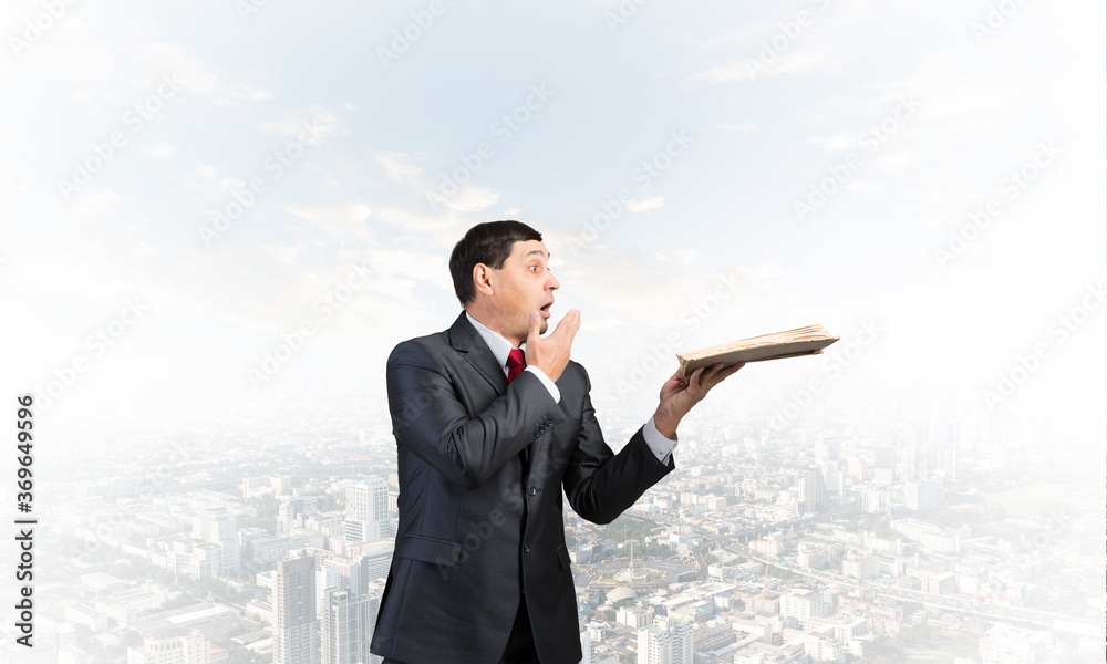 Embarrassed businessman covering mouth with hand Embarrassed businessman covering mouth with hand