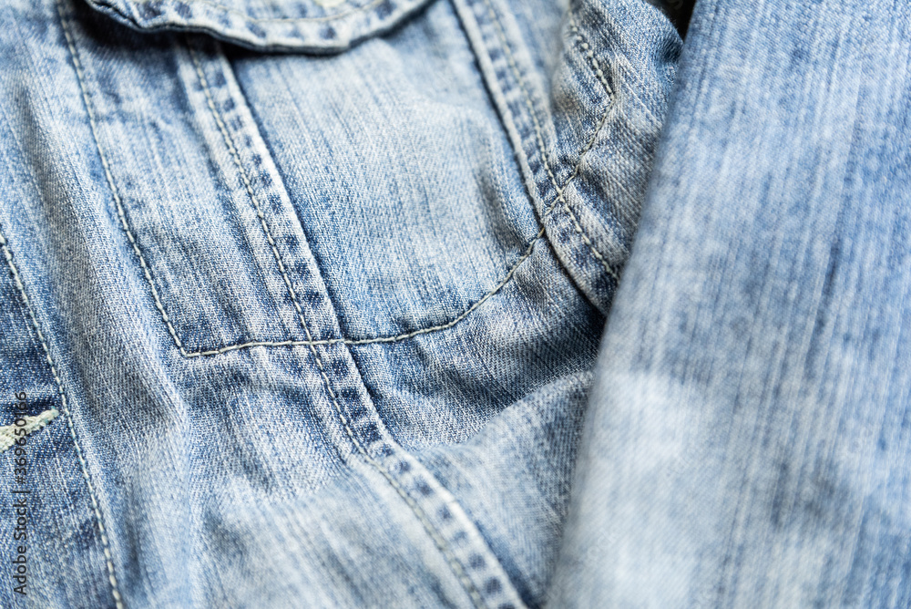 Detail of the pocket of a blue denim jeans. Blue denim jacket.