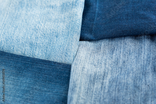 Different shades of blue denim fabric. Detail of several layers of jeans.