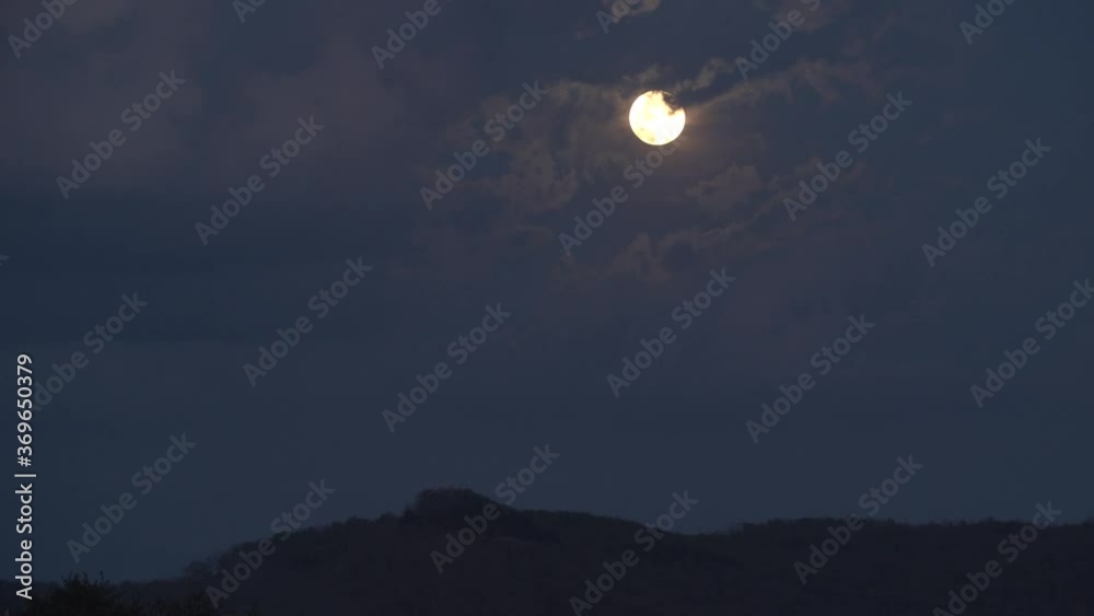 A spring time day to night timelapse of a moon rise behind puffy clouds in the Appalachian hills. A spring time day to night timelapse of a moon rise behind puffy clouds in the Appalachian hills.