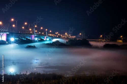 The beautiful dense foggy nightscape with bridge and lanterns light in the night.