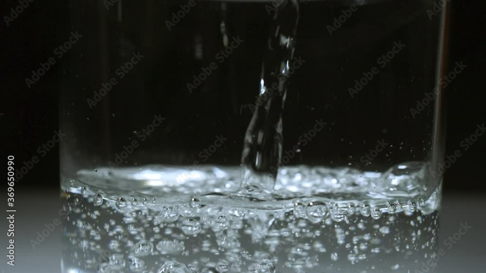 Carbonated water pouring from top of frame into glass in SLOW MOTION 240fps - Dark scene - Shot locked off on tripod - Shot in 2k exported to 1080p Carbonated water pouring from top of frame into glass in SLOW MOTION 240fps - Dark scene - Shot locked off on tripod - Shot in 2k exported to 1080p