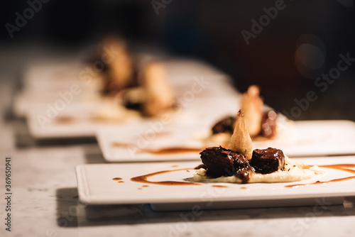 Detalle de plato gourmet de carne de ternera sobre base de hummus