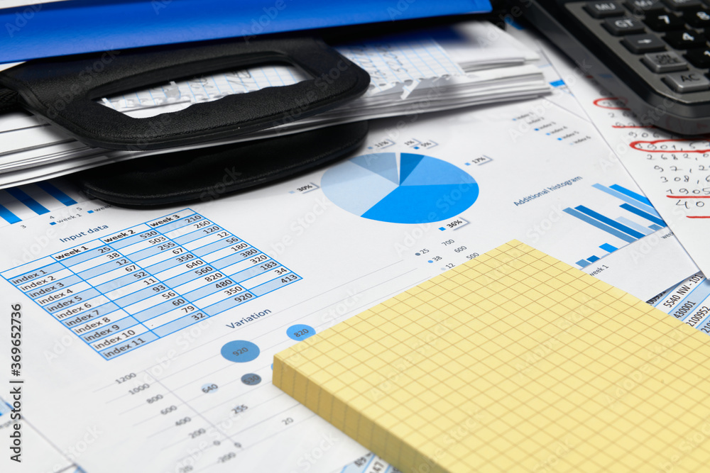 business office desk closeup - financial reports, analysis and accounting, set of documents, tables and graphs, various items for bookkeeping, calculator business office desk closeup - financial reports, analysis and accounting, set of documents, tables and graphs, various items for bookkeeping, calculator