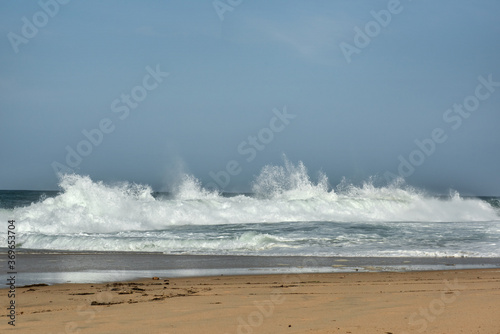 The big breaking waves during a strom at the beautiful summer sea shore background the blue sky and horizon