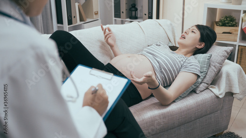 Worried pregnant woman talking to doctor while lying on sofa. Sad expectant lady having conversation and complaining with psychologist. Healthcare consultation pregnancy problems childbirth concept