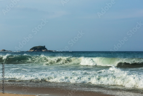 Fototapeta Naklejka Na Ścianę i Meble -  The huge waves crashing into ston island against the blue sky and horizon at summer sea shore.
